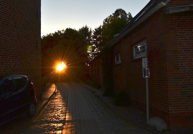 Pilsum an der Kirche Sonnenuntergang durch die Bäume