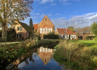 Loquard am Burggraben mit der historischen Kirche im Hintergrund
