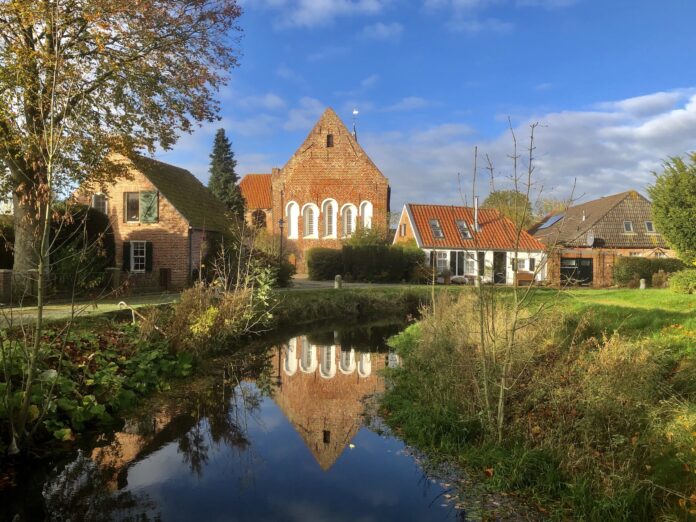 Loquard am Burggraben mit der historischen Kirche im Hintergrund